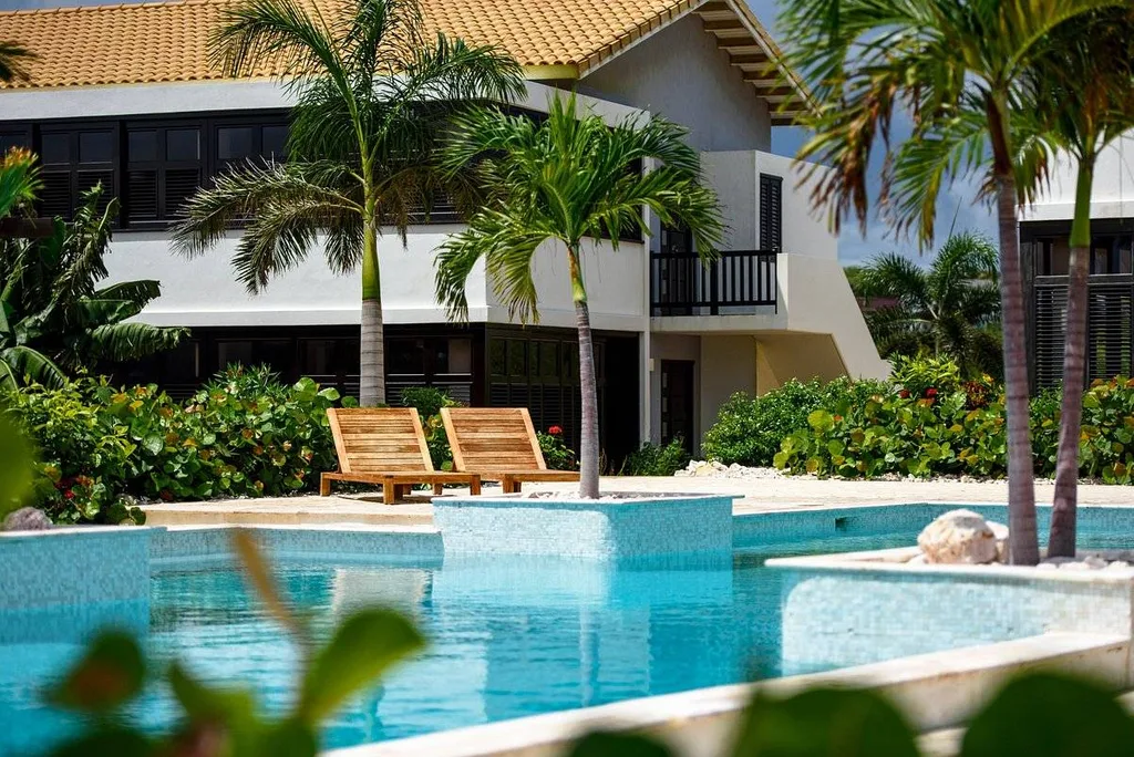 two wooden lounge chairs next to swimming pool