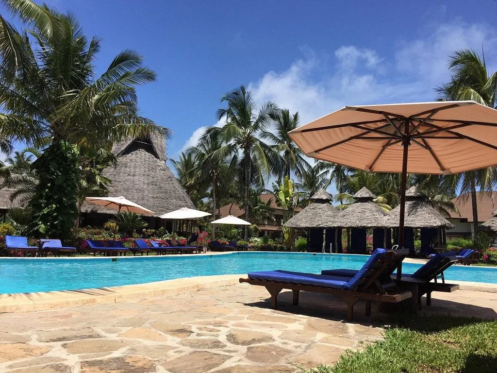 resort pool with lawn chairs and palm trees