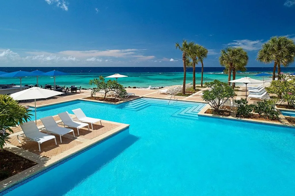 square resort pool with palm trees at ocean
