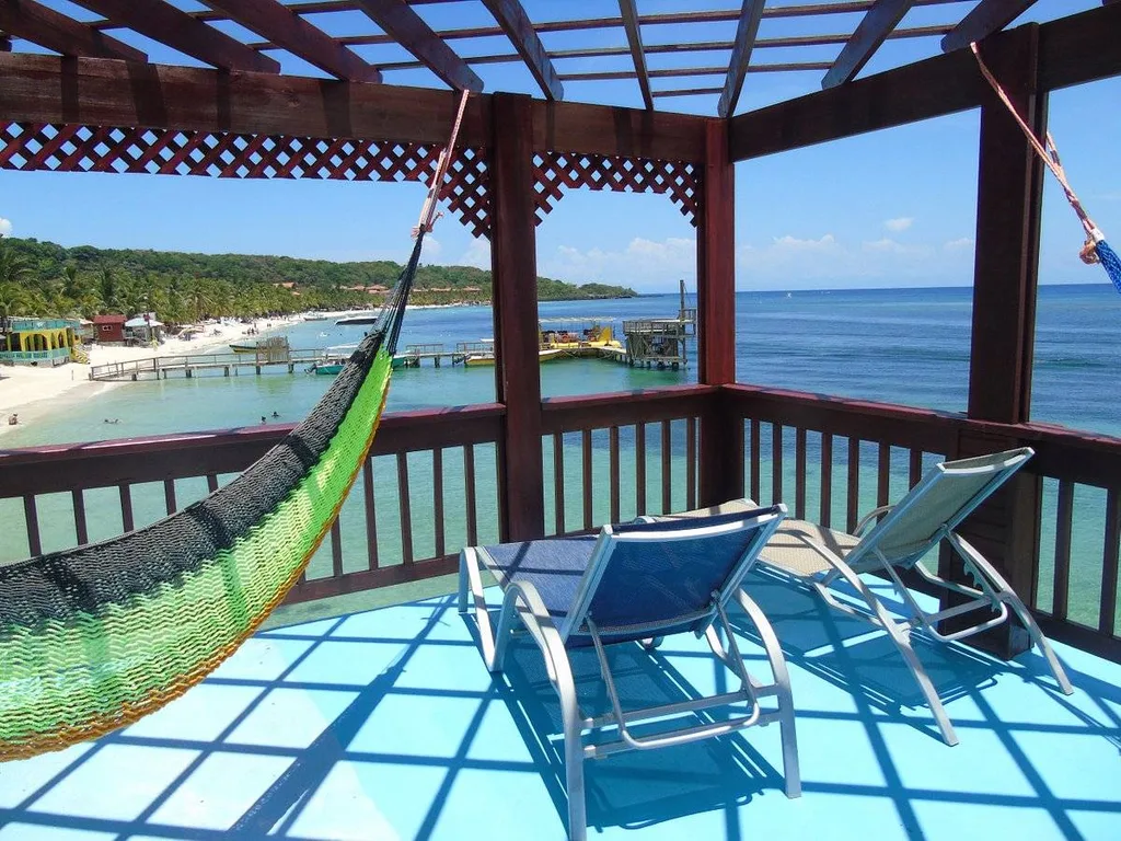 two lounge chairs and hammock on patio on the beach