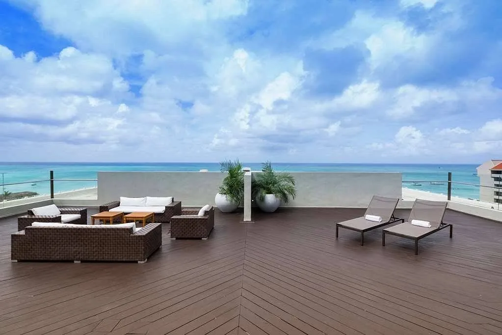 patio furniture on large wooden deck near ocean