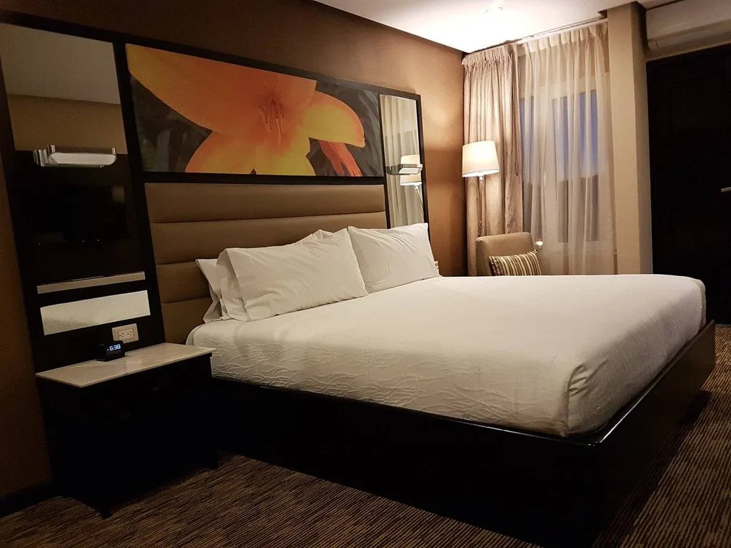 hotel room bed with picture of yellow flower over bed