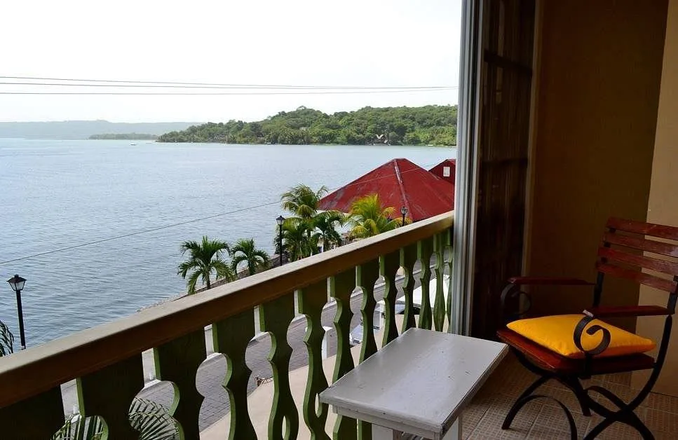 chair with orange cushion on balcony at ocean