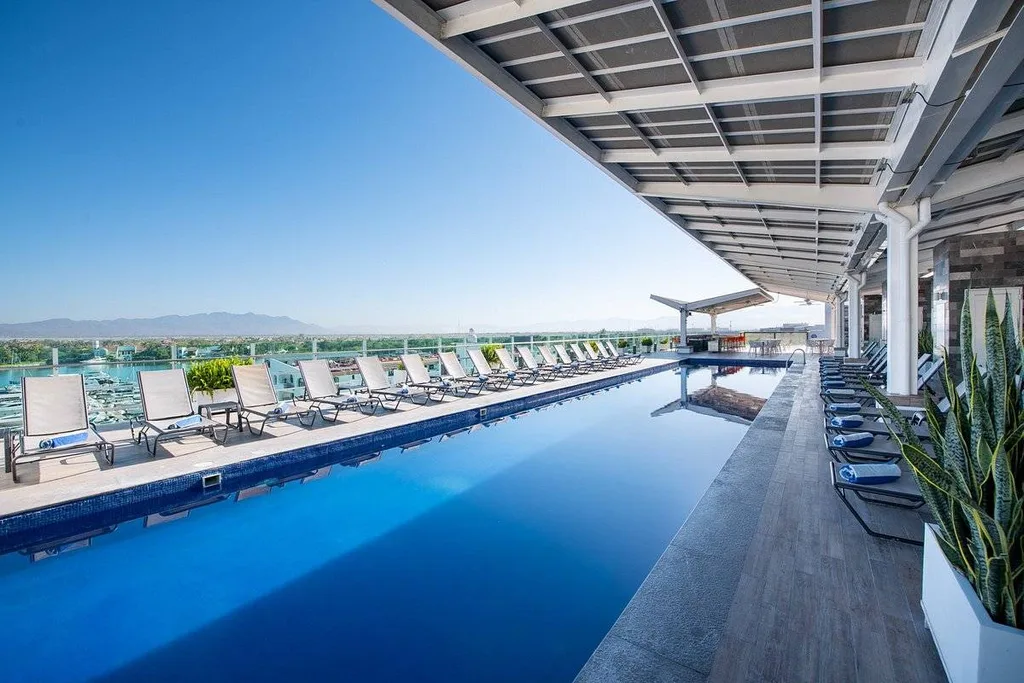 long resort pool with white lounge chairs