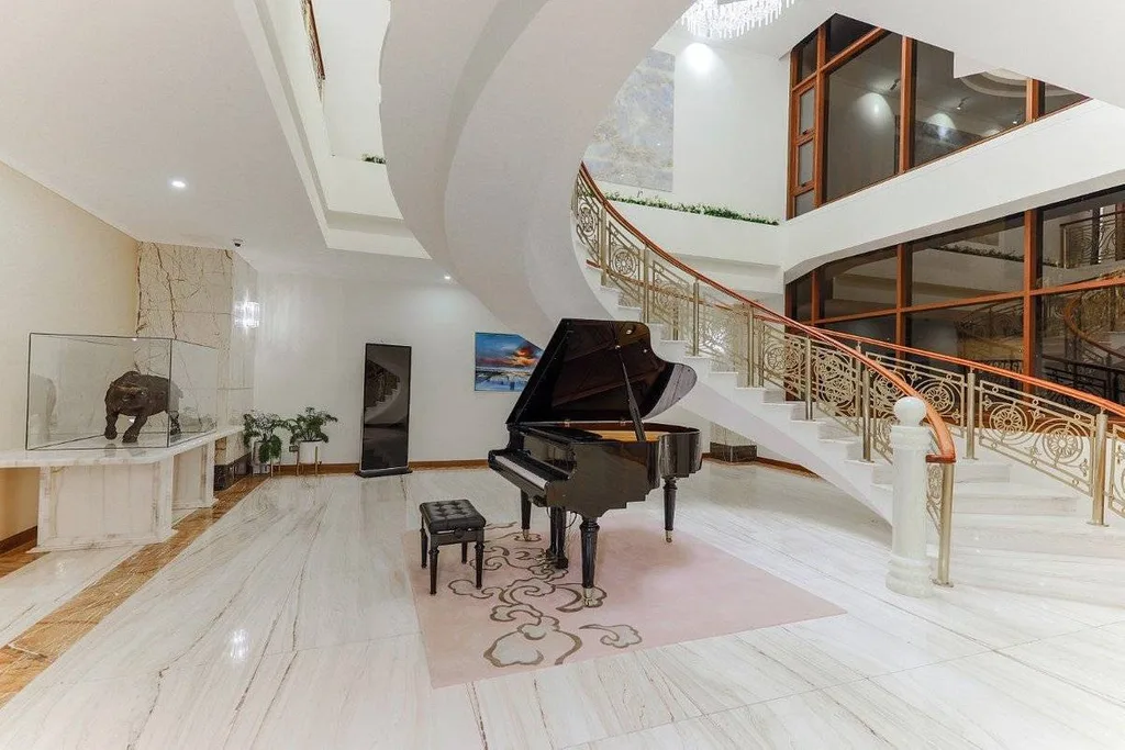 piano in lobby of hotel with winding staircase