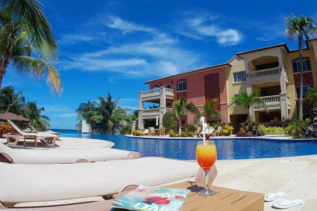 orange drink on table by resort pool