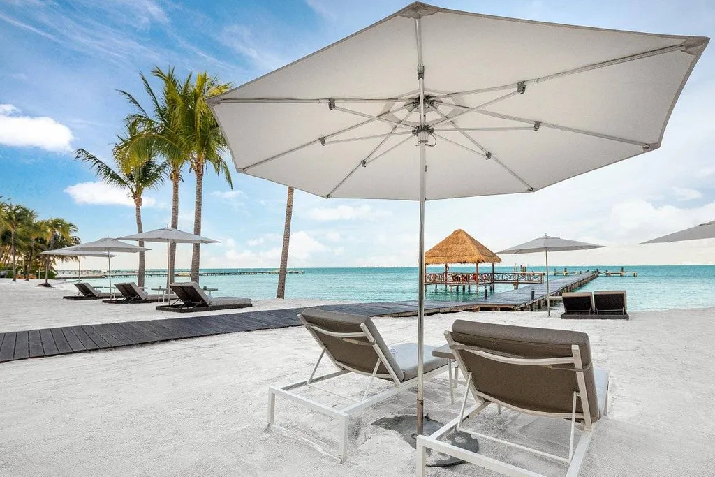 two lounge chairs under umbrella at resort pool