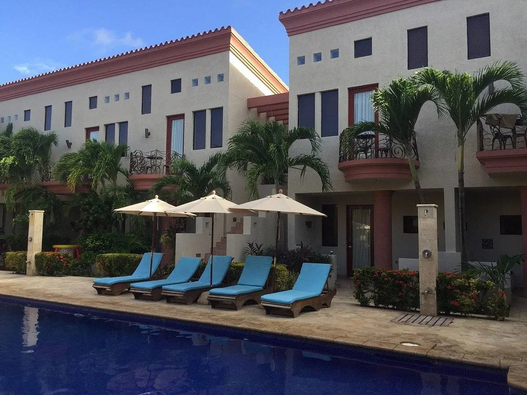 5 blue lounge chairs and 3 umbrellas by pool