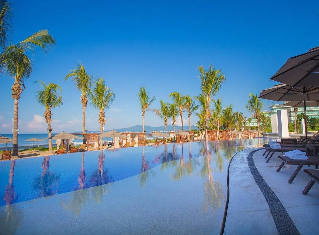 infinity pool with palm trees and lounge chairs