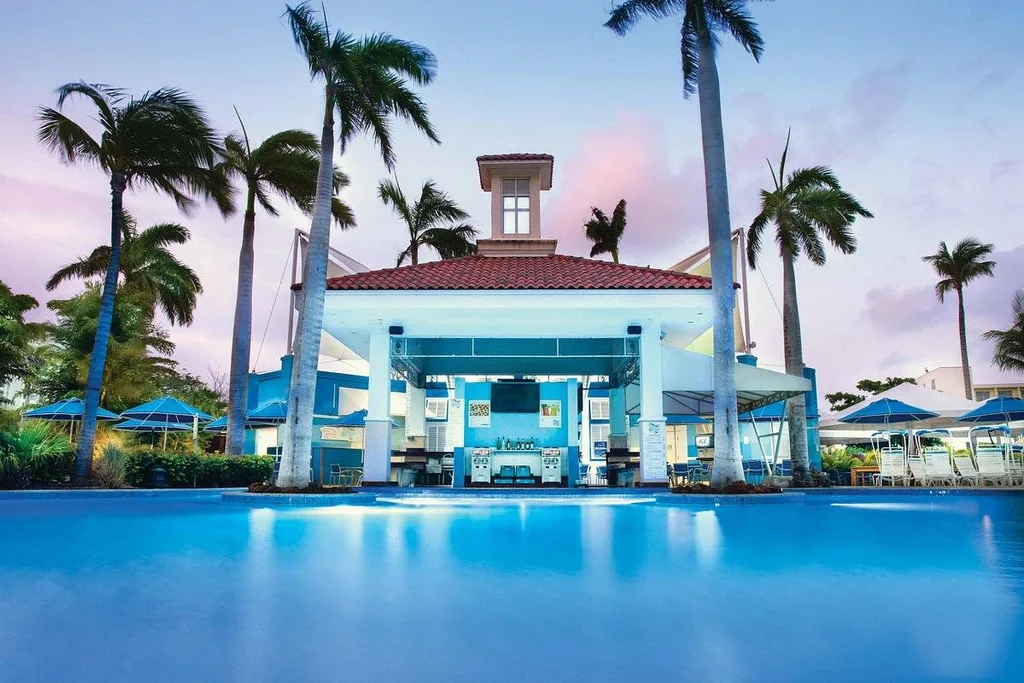 building and palm trees in front of pool at dusk