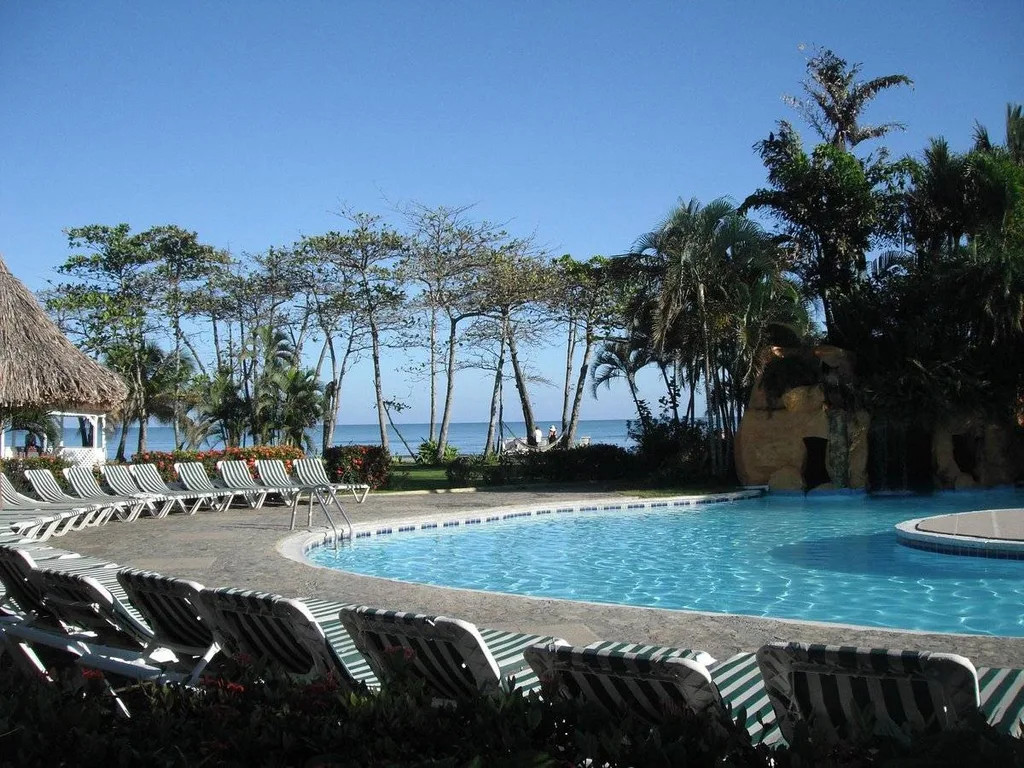 curved resort pool with many lounge chairs