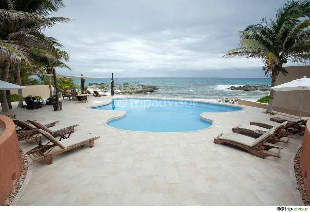 resort pool at ocean with lounge chairs
