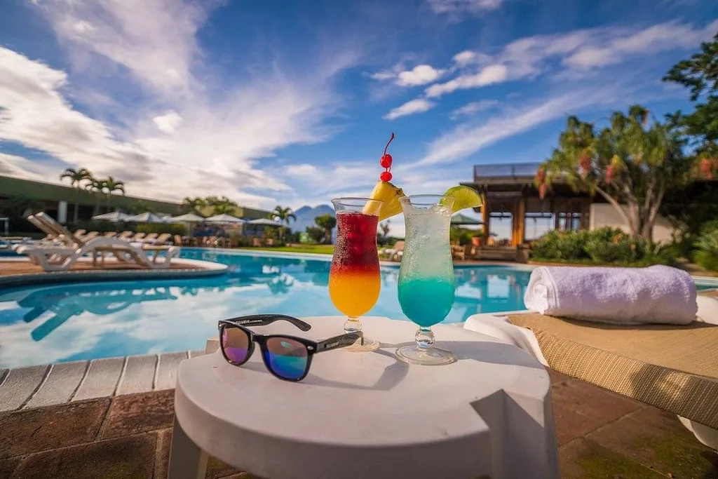 drinks and sunglasses on table at pool