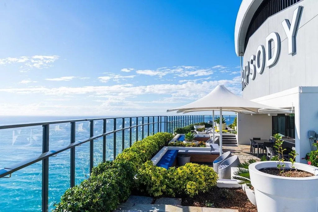 long patio with bushes at the ocean