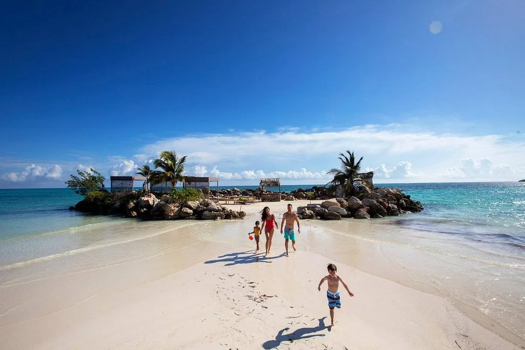 family walking on white sand beach