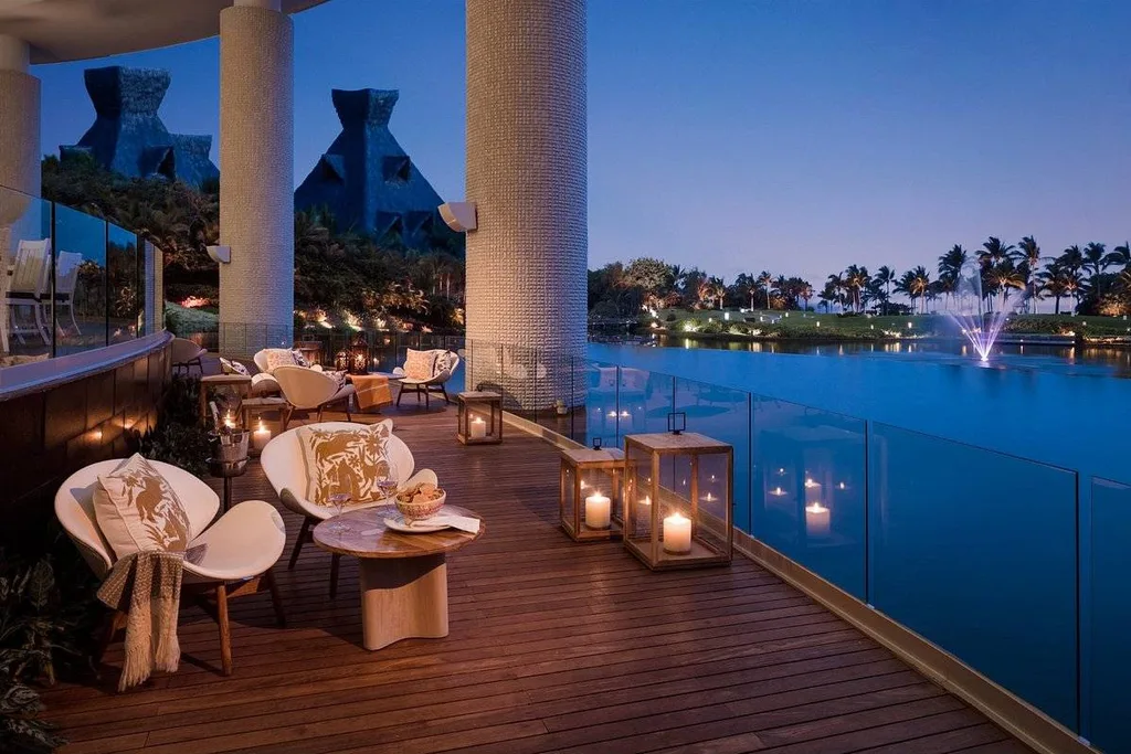 patio with candles next to pool at night 