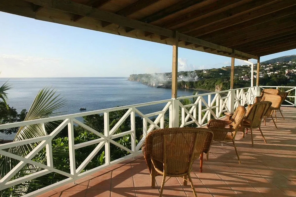 wicker chairs on covered patio in front of ocean