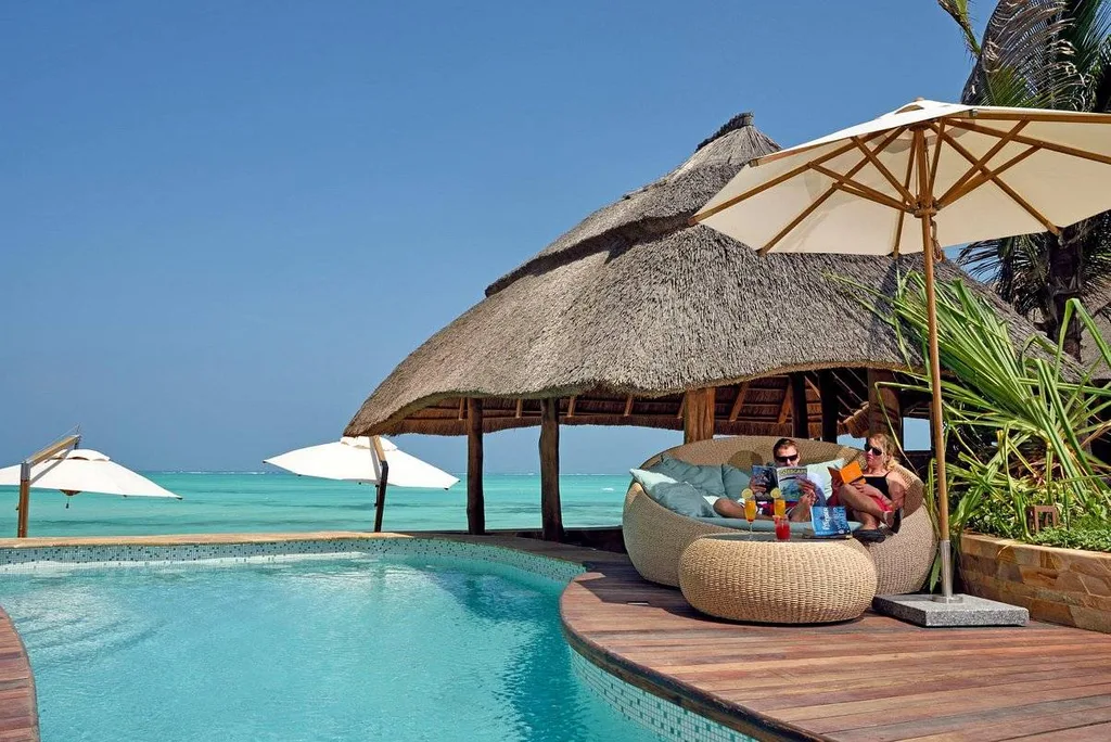 resort pool with wooden deck and umbrellas