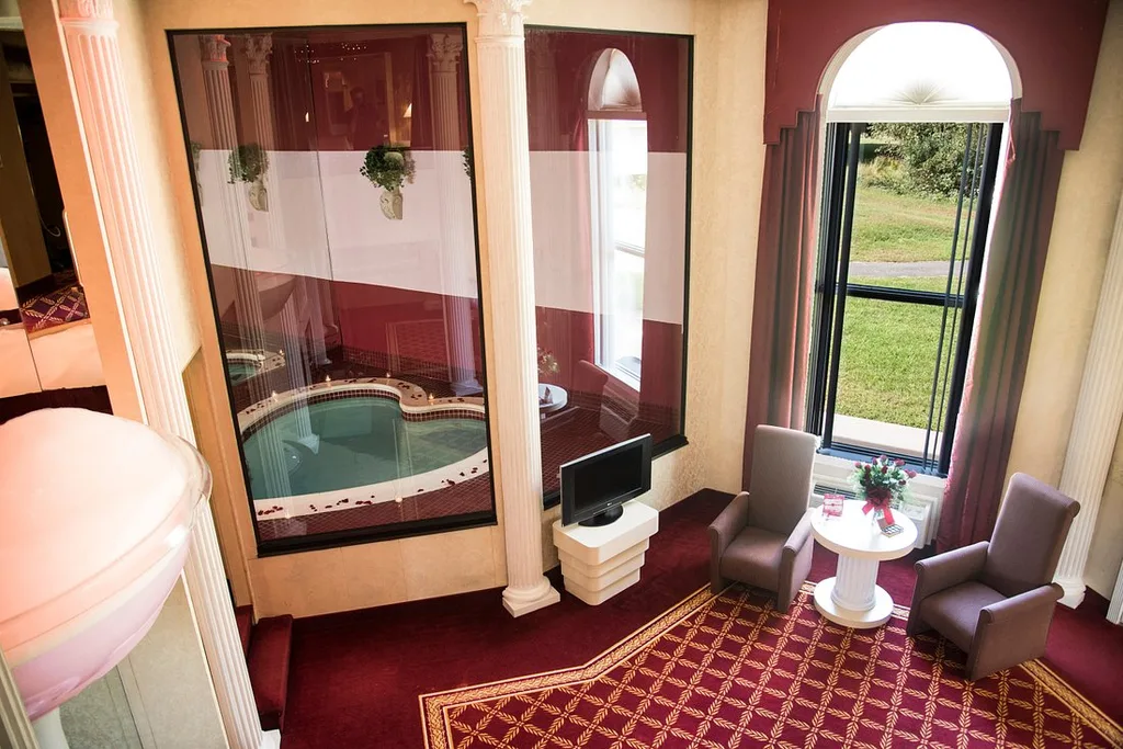 resort room with heart shaped tub with red carpet