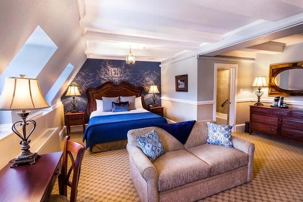 large resort room with fancy bed and loveseat