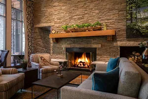 ski lodge with fireplace made of stone going up entire wall