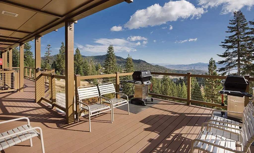 wooden patio with mountains and trees in background