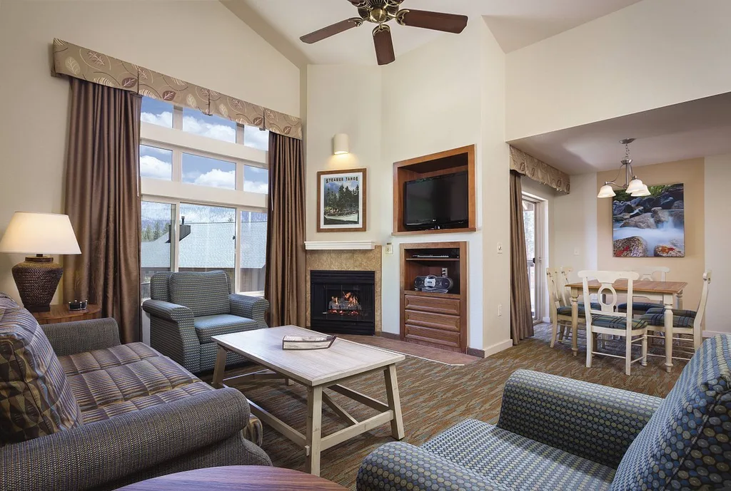 high ceiling resort room with ceiling fan and gray furniture
