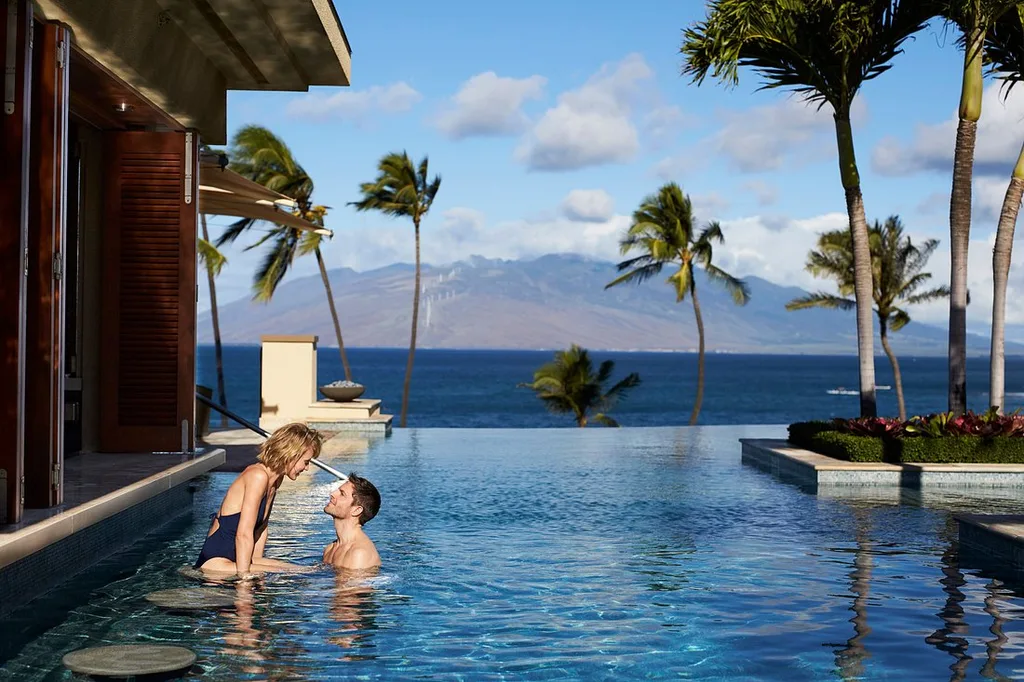 Four Seasons Resort Maui at Wailea couple in infinity pool with volcano in background