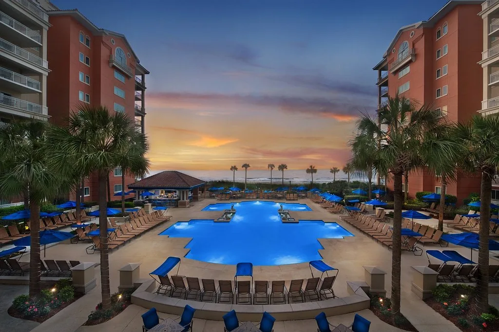 Marriott's OceanWatch Villas at Grande Dunes lighted pool between buildings at sunset