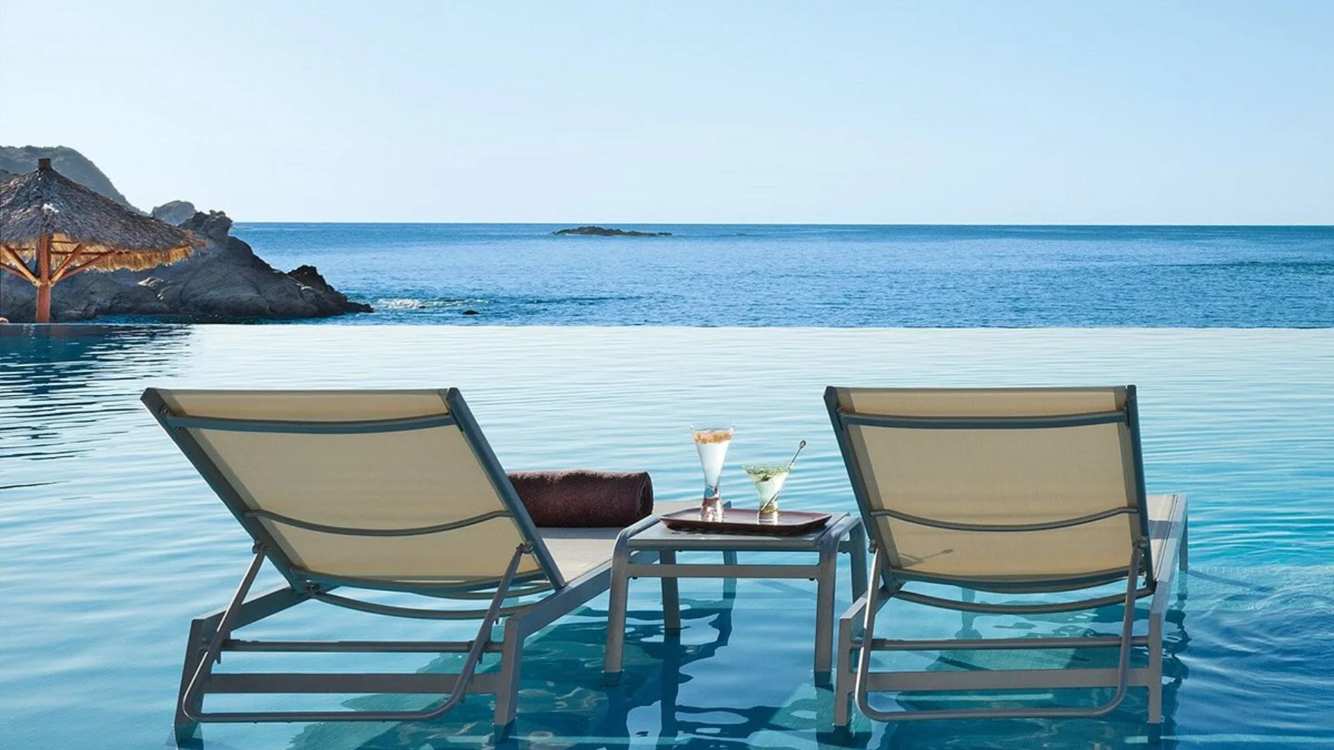 two lounge chairs in infinity pool