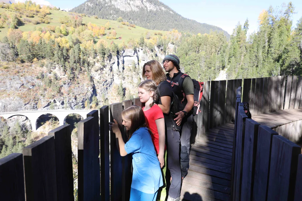 eine Familie schaut über die Brücke auf den Wasserfall