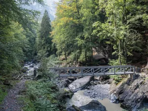 Metallischer Fussgängersteg über einen kleinen Fluss