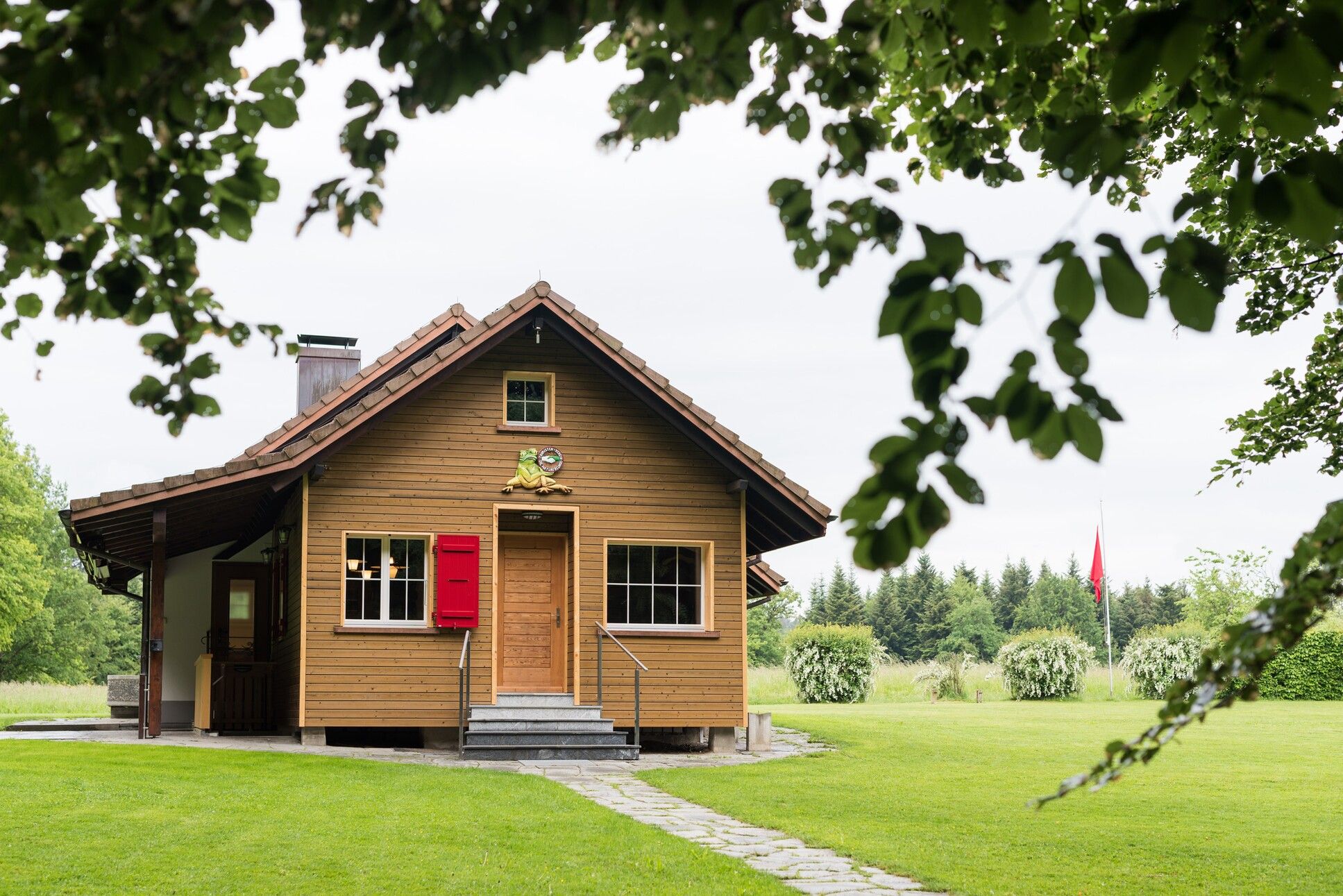 une maison en bois avec une porte rouge 