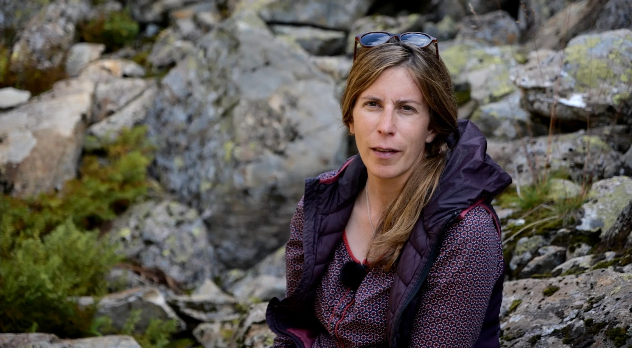 eine Frau, die auf einem Felsen im Wald sitzt