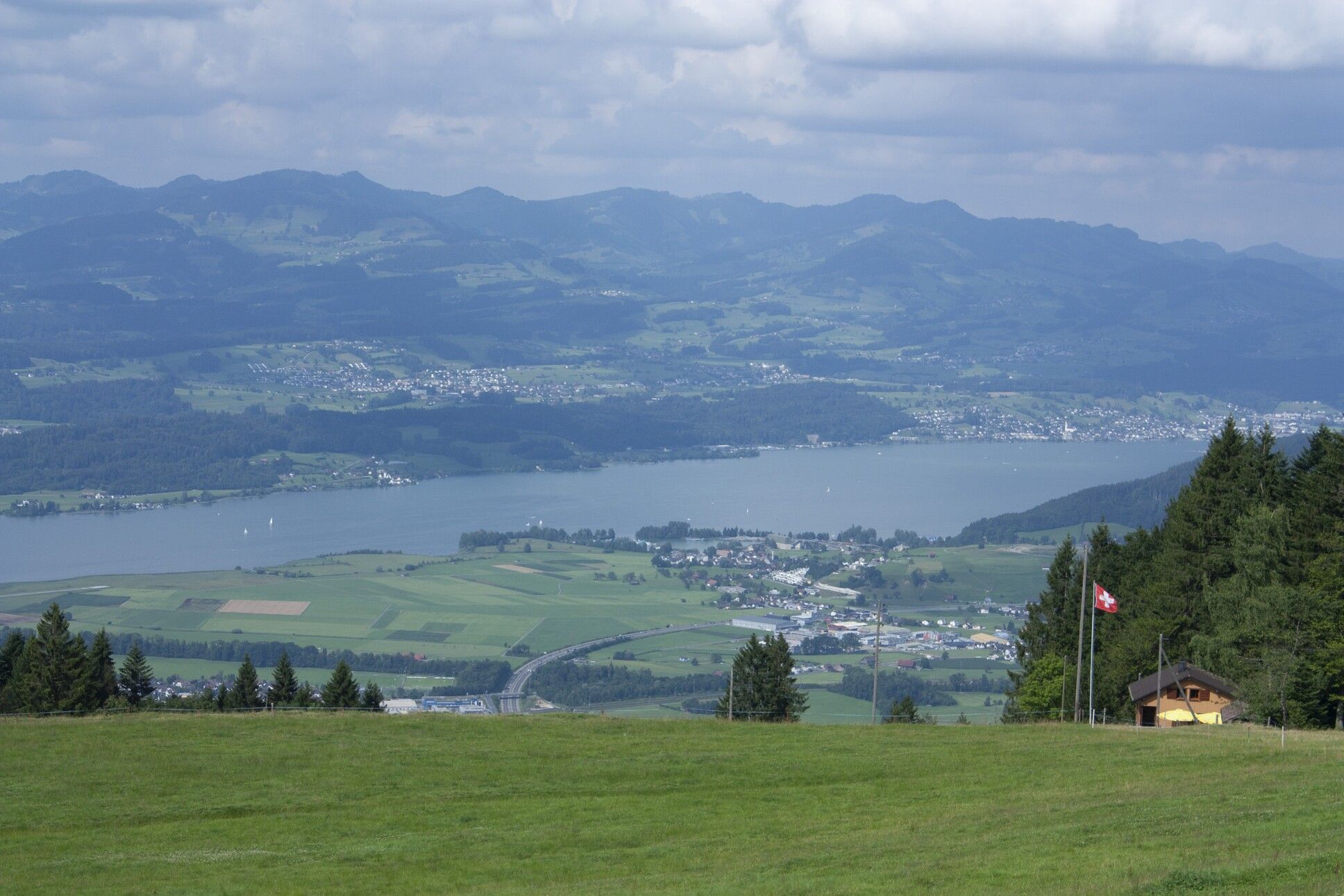 Blick auf einen See und die Berge von einem Hügel aus 