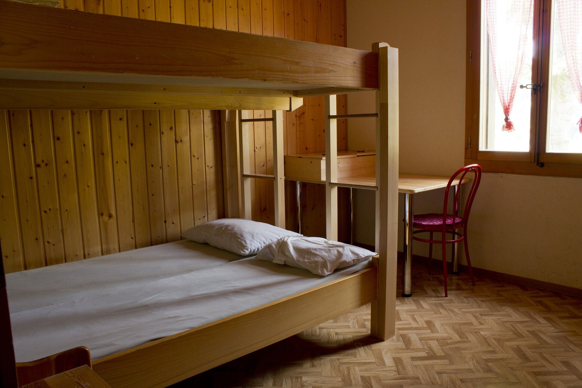 ein hölzernes Etagenbett mit einem weißen Kissen oben drauf 