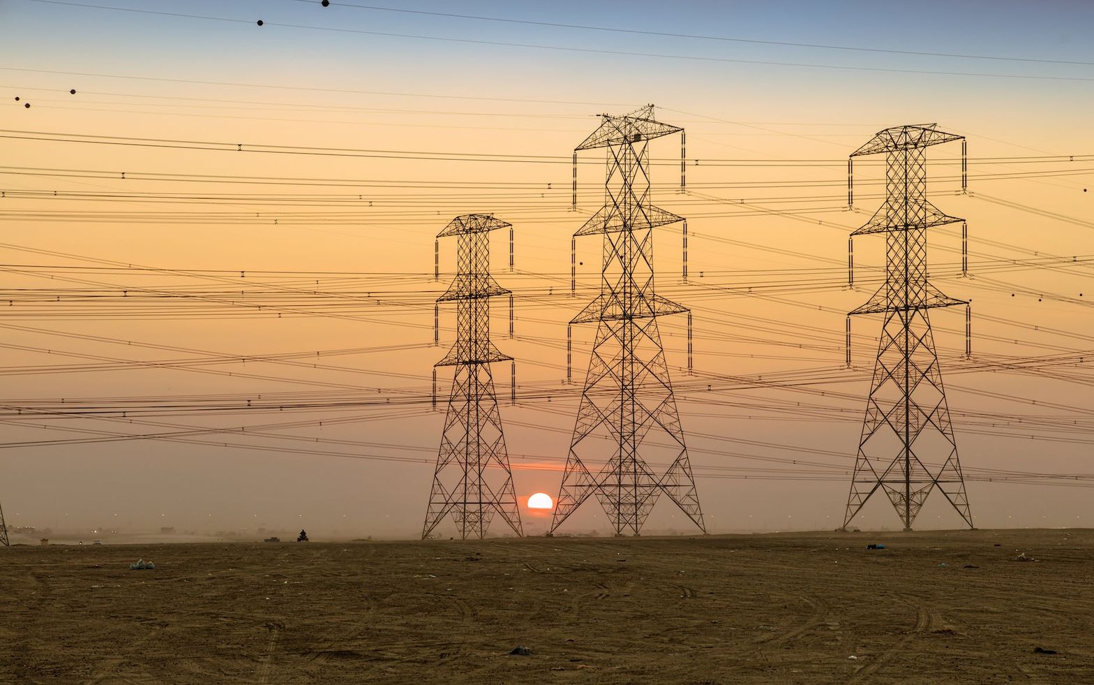 silhouette of electric towers during sunset