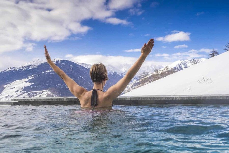 Wellnesshotels an der Skipiste bieten oft einen traumhaften Pool-Ausblick direkt auf verschneite Berge.