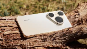 Ağaç gövdesi üzerinde duran açık renkli Huawei Pura 90s Pro Max’in arka yüzü ve üçlü kamera modülü