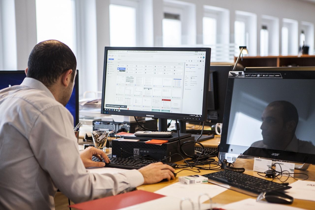 in loondienst en als zzp - op de foto is een meneer te zien die werkt achter een computer
